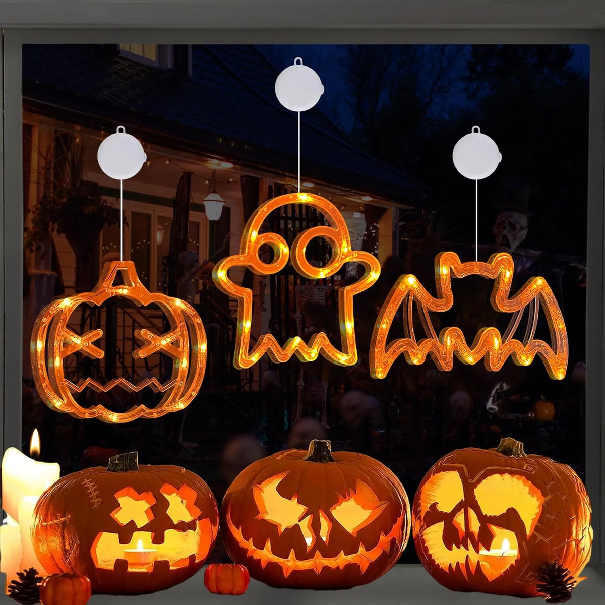 Pumpkin, ghost and bat lights arranged in a Halloween window