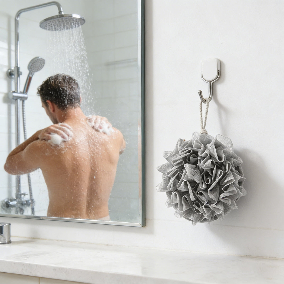 Gray mesh bath puff hanging beside a shower