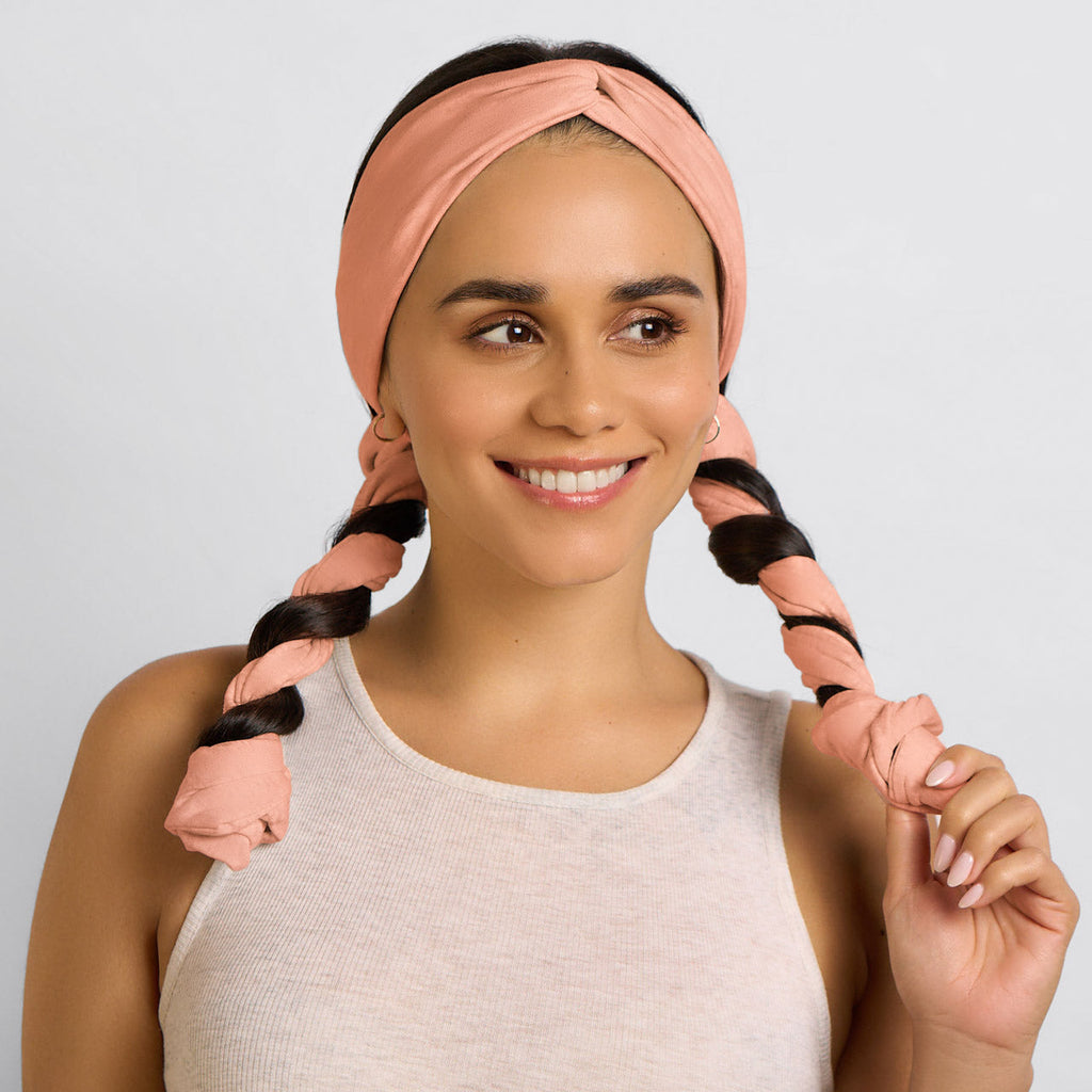 Orange curling headband with hair wrapped around its tails