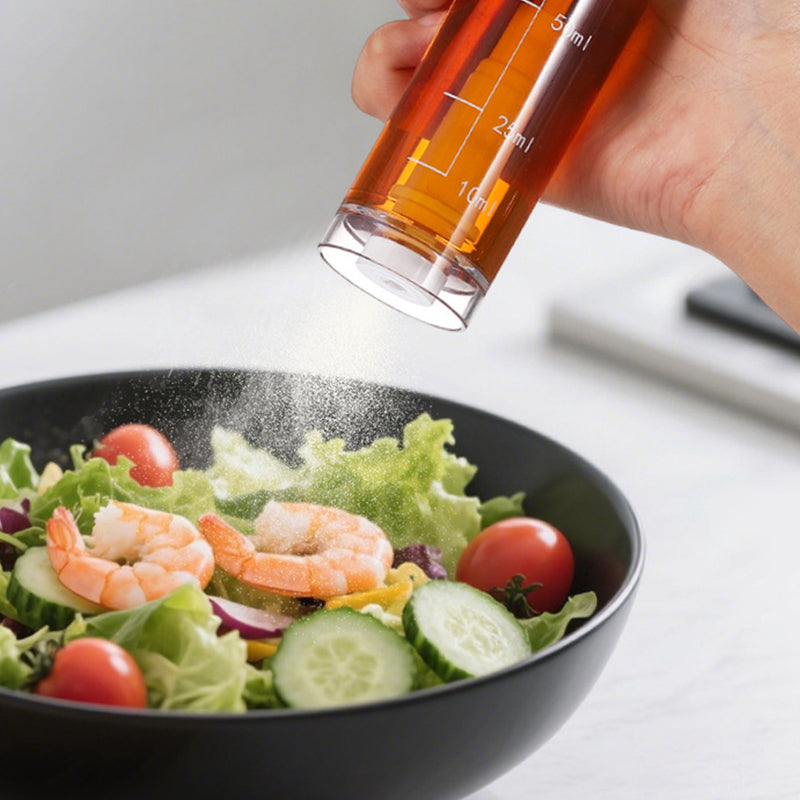 Cooking oil sprayer being used over a salad