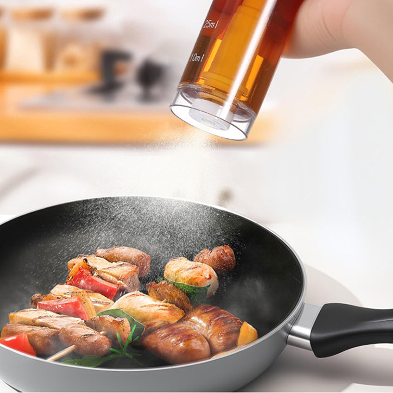 Cooking oil sprayer above a pan of food