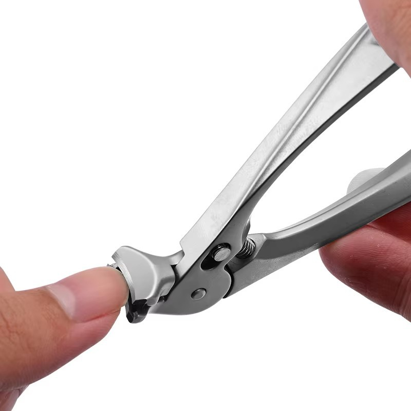 Silver nail clipper held near a fingernail