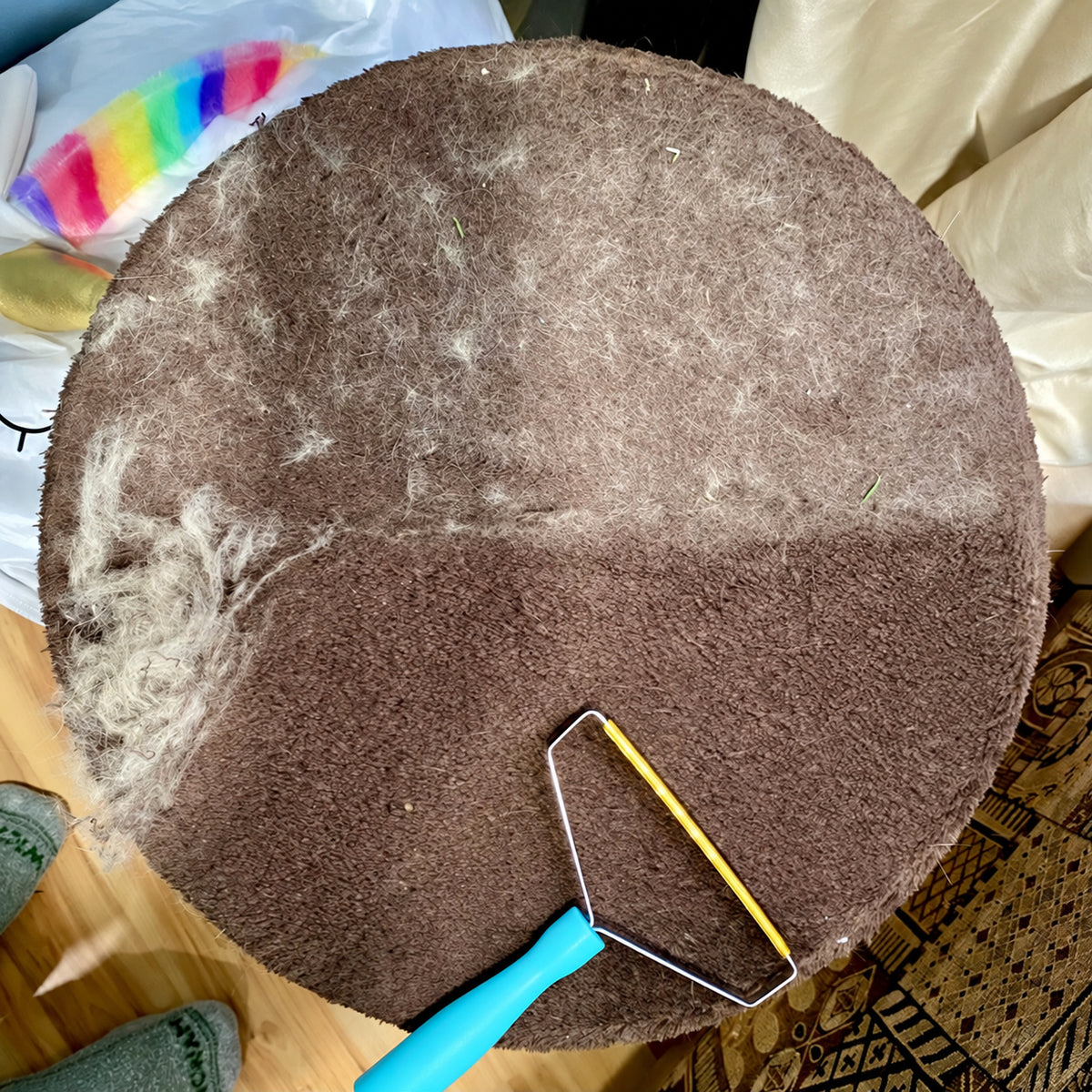 Hair remover used on a round fabric-covered cat-tree platform