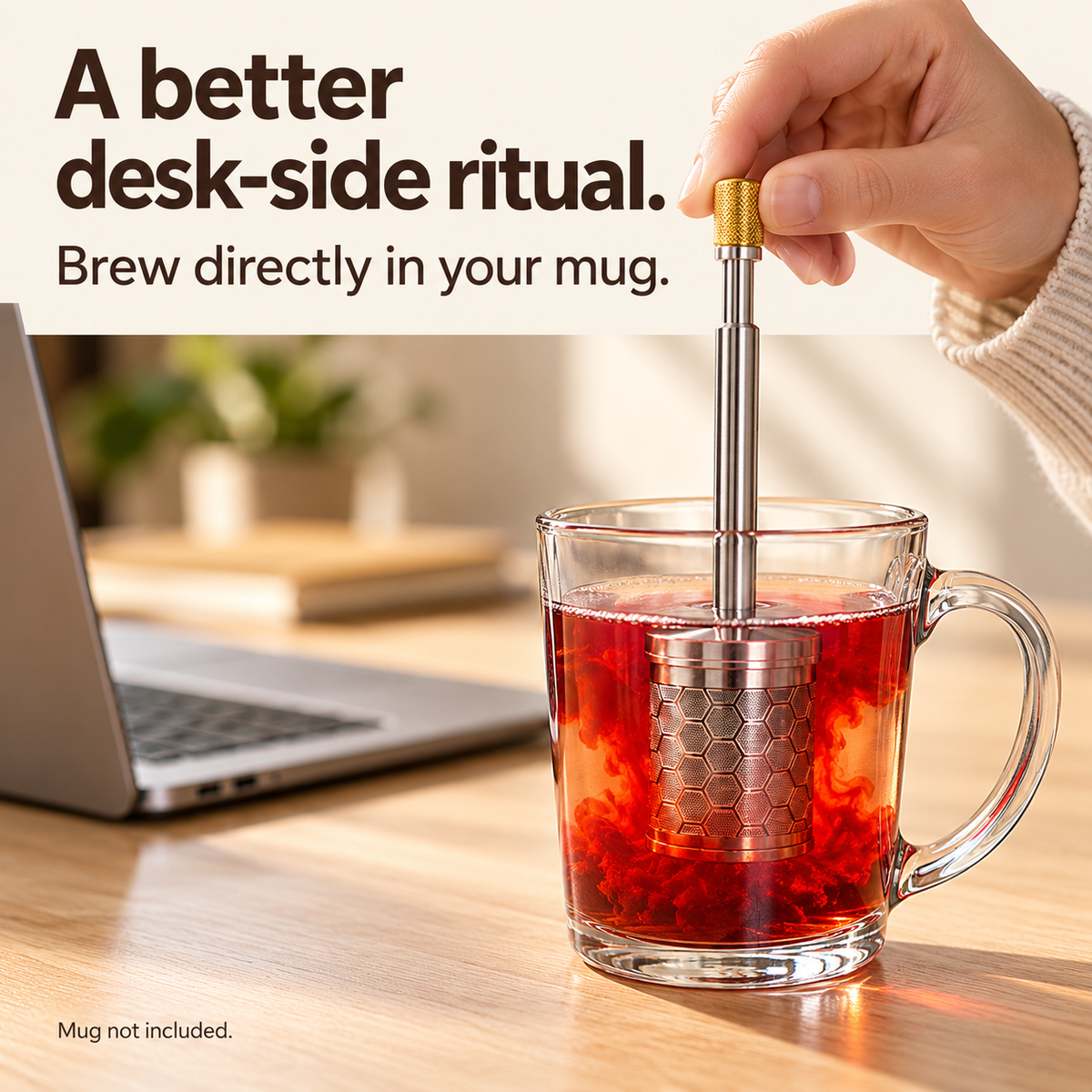 Manual brewer steeping tea beside a laptop