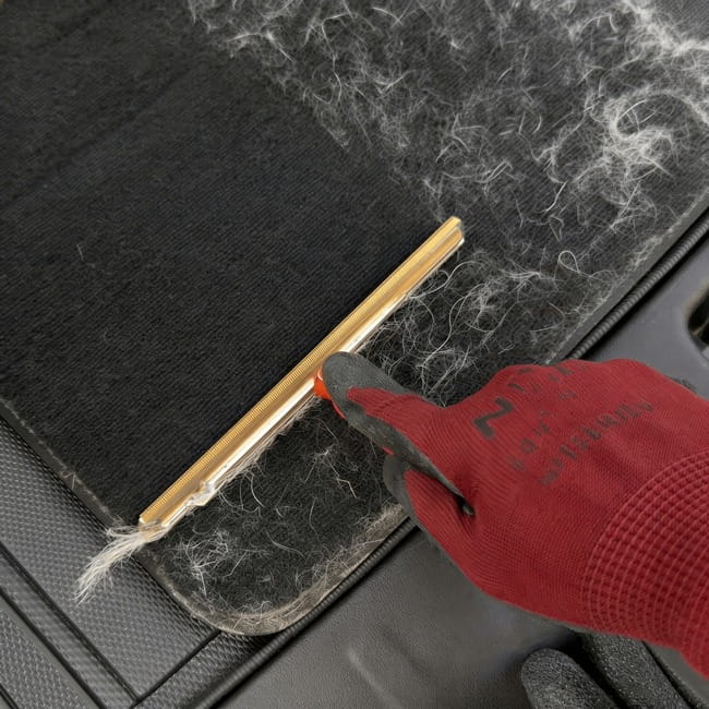 Red pet hair scraper on a car seat